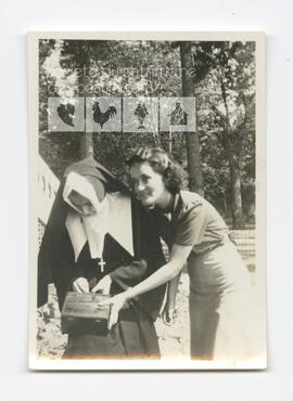 Lucienne Routhier, sœur Sainte-Marie de la Croix, ouvrant une boîte de papier à lettres tenue par Jeanne Routhier, devant le couvent